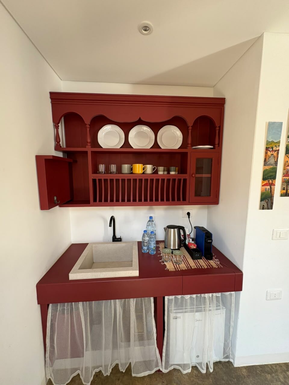 Tale coffee corner with a clay-red cabinet, plate rack, kettle and espresso machine