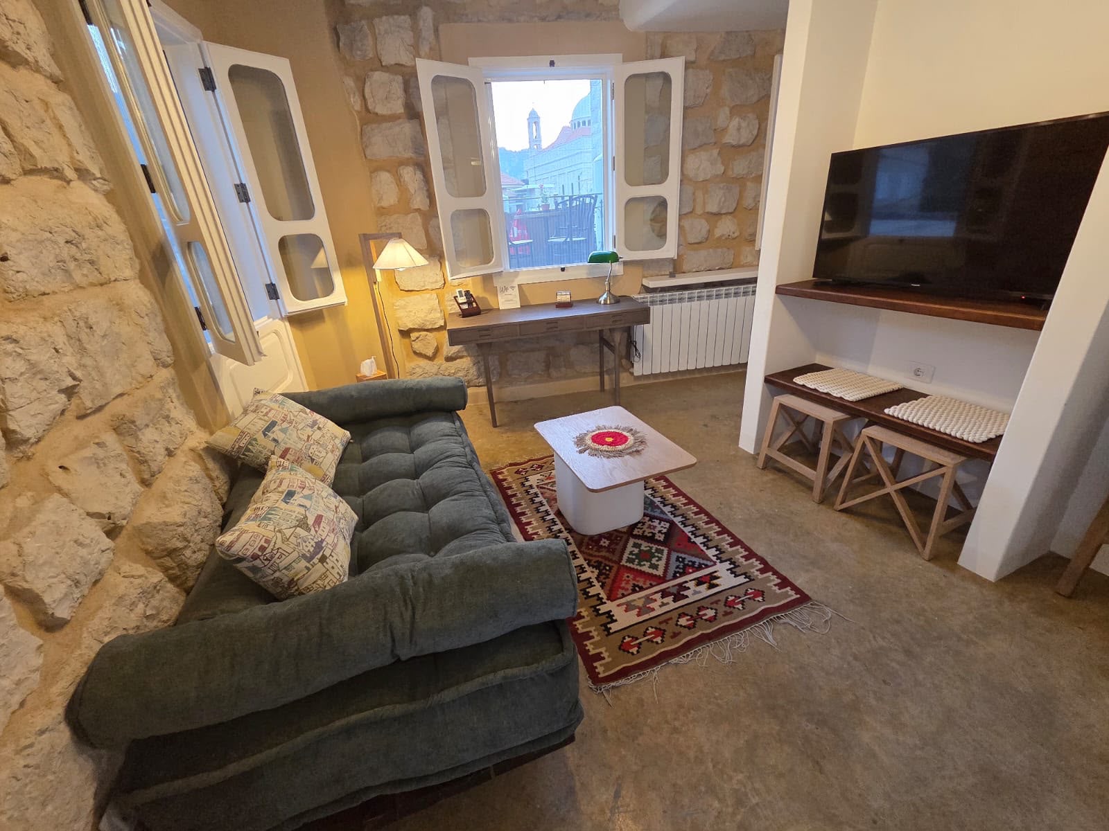 Whisper room sitting corner with green daybed and kilim rug
