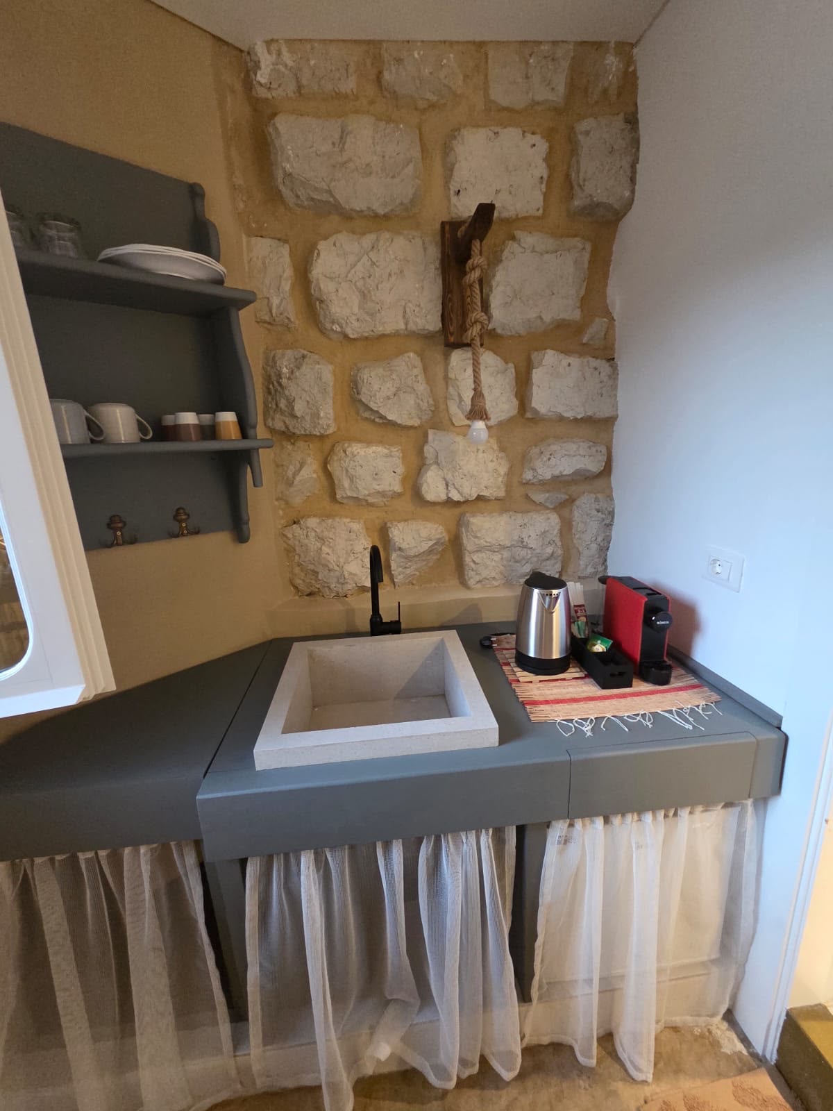 Whisper room coffee corner with carved stone basin, kettle and espresso machine